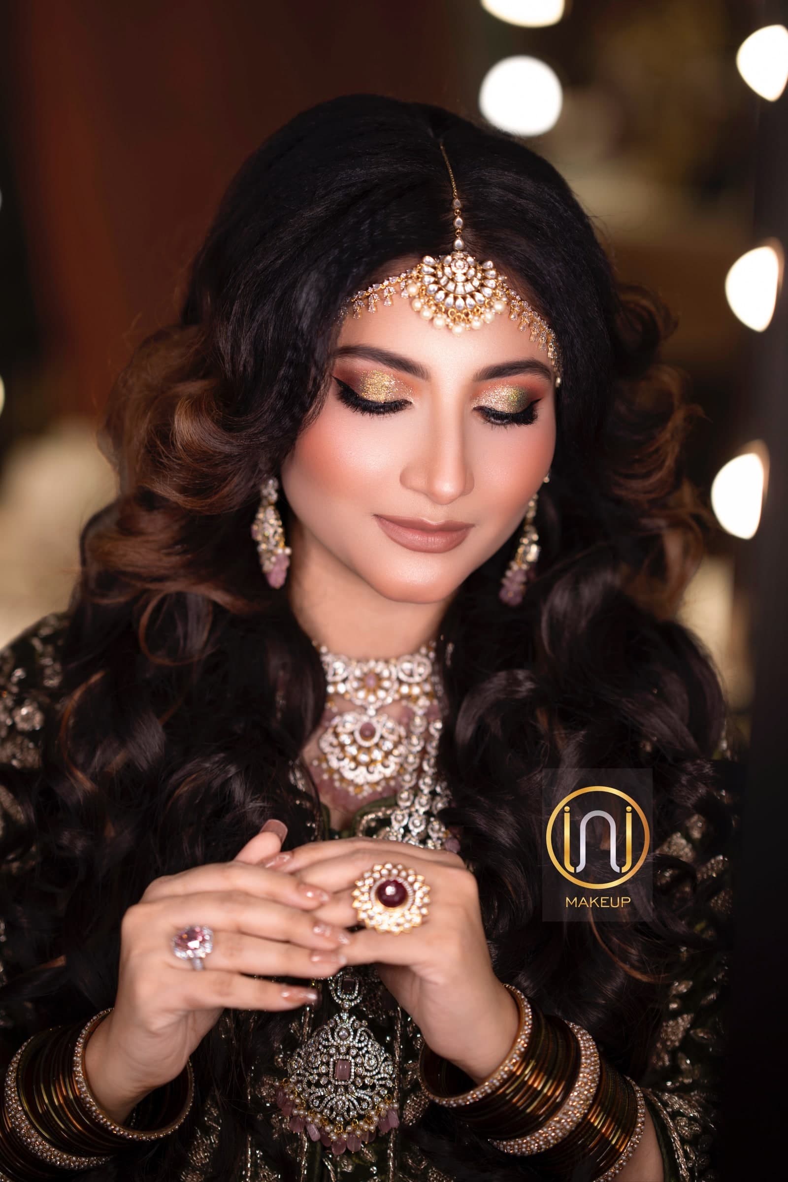 Evening occasion look in deep green velvet with cascading waves, a diamond choker and multi-tone glitter eye makeup