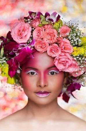Creative editorial makeup with pink tones framed by a crown of roses